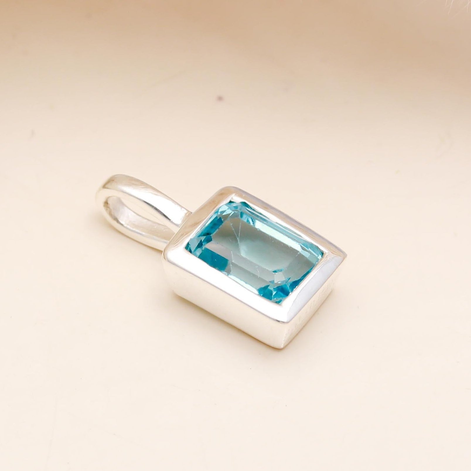 The Azure Prism: Blue Topaz Silver Charm