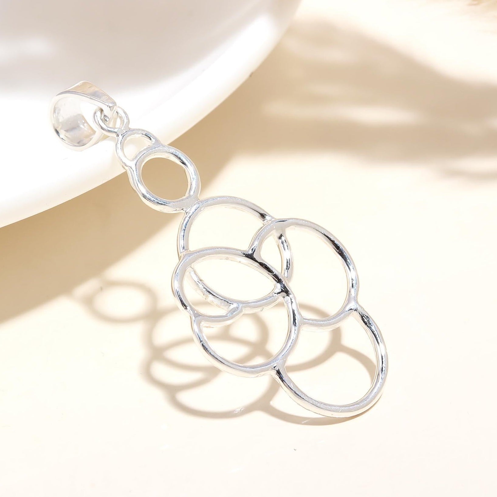 A sterling silver pendant necklace with a geometric design, displayed on a neutral background.