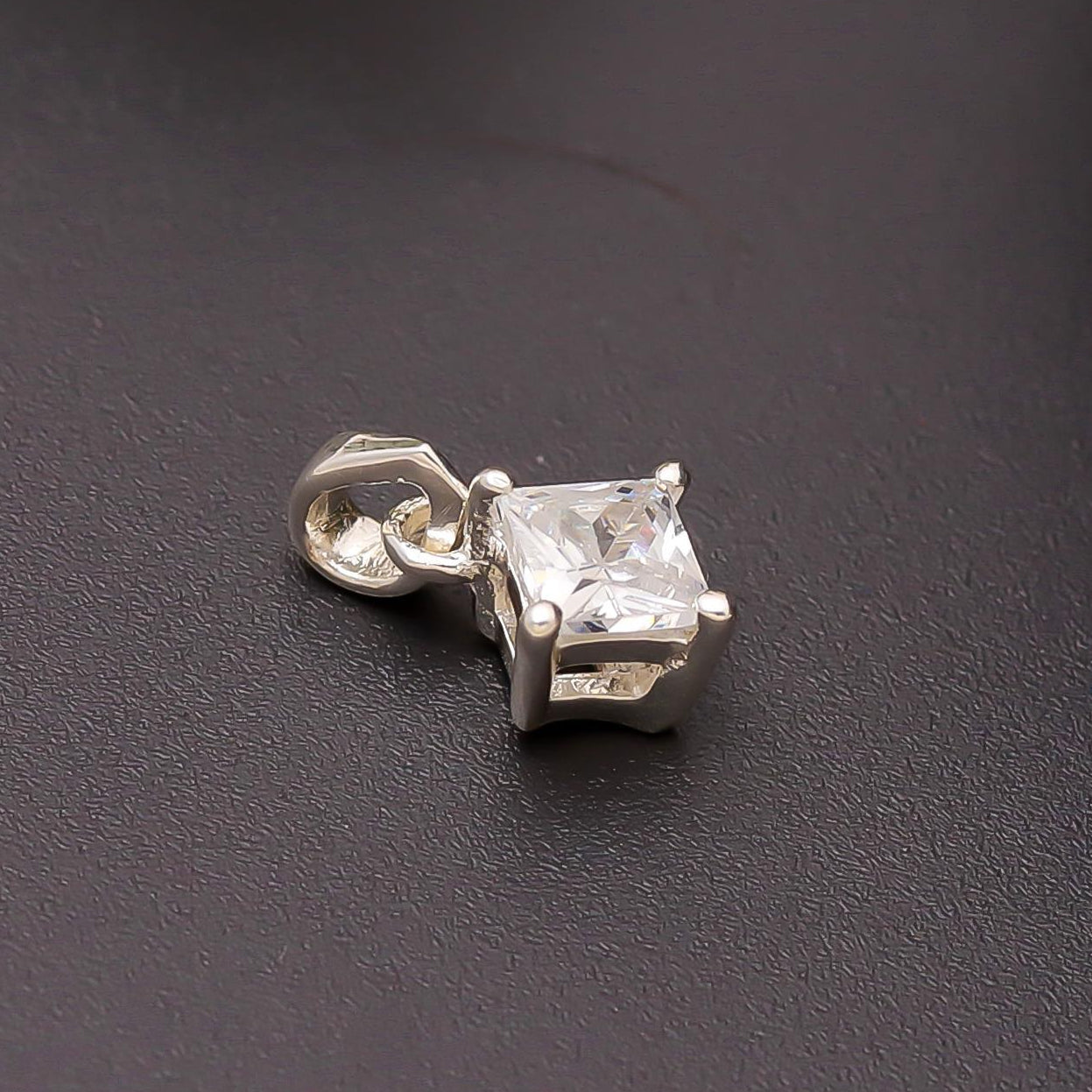 A 925 silver princess-cut solitaire pendant with a cubic zirconia stone on a dark background.