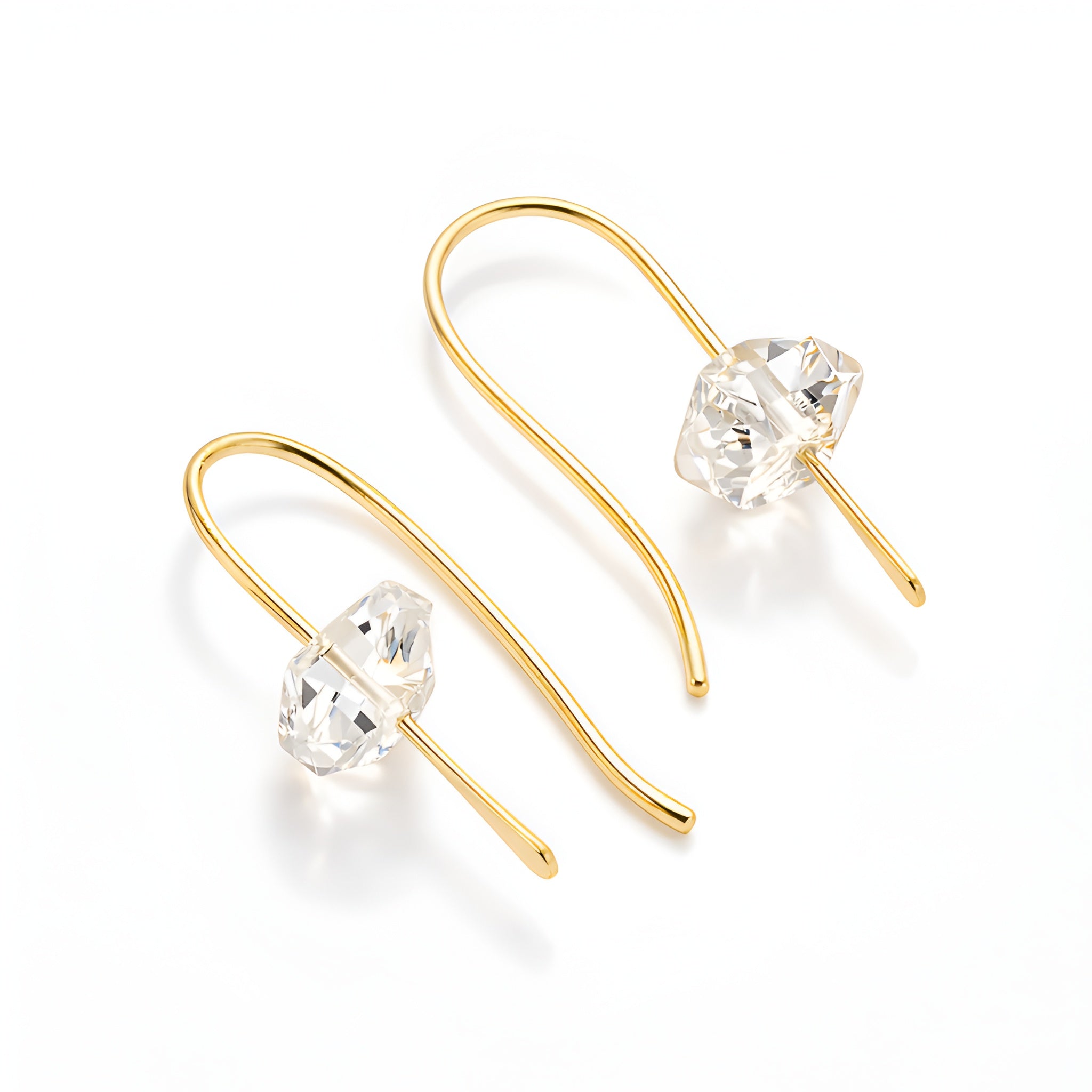 Gold earrings with clear gemstones on a white background