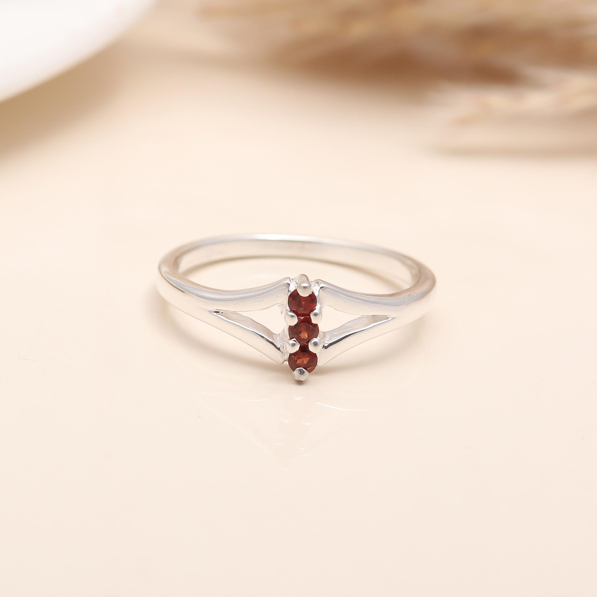 Modern sterling silver ring featuring trio garnet stones