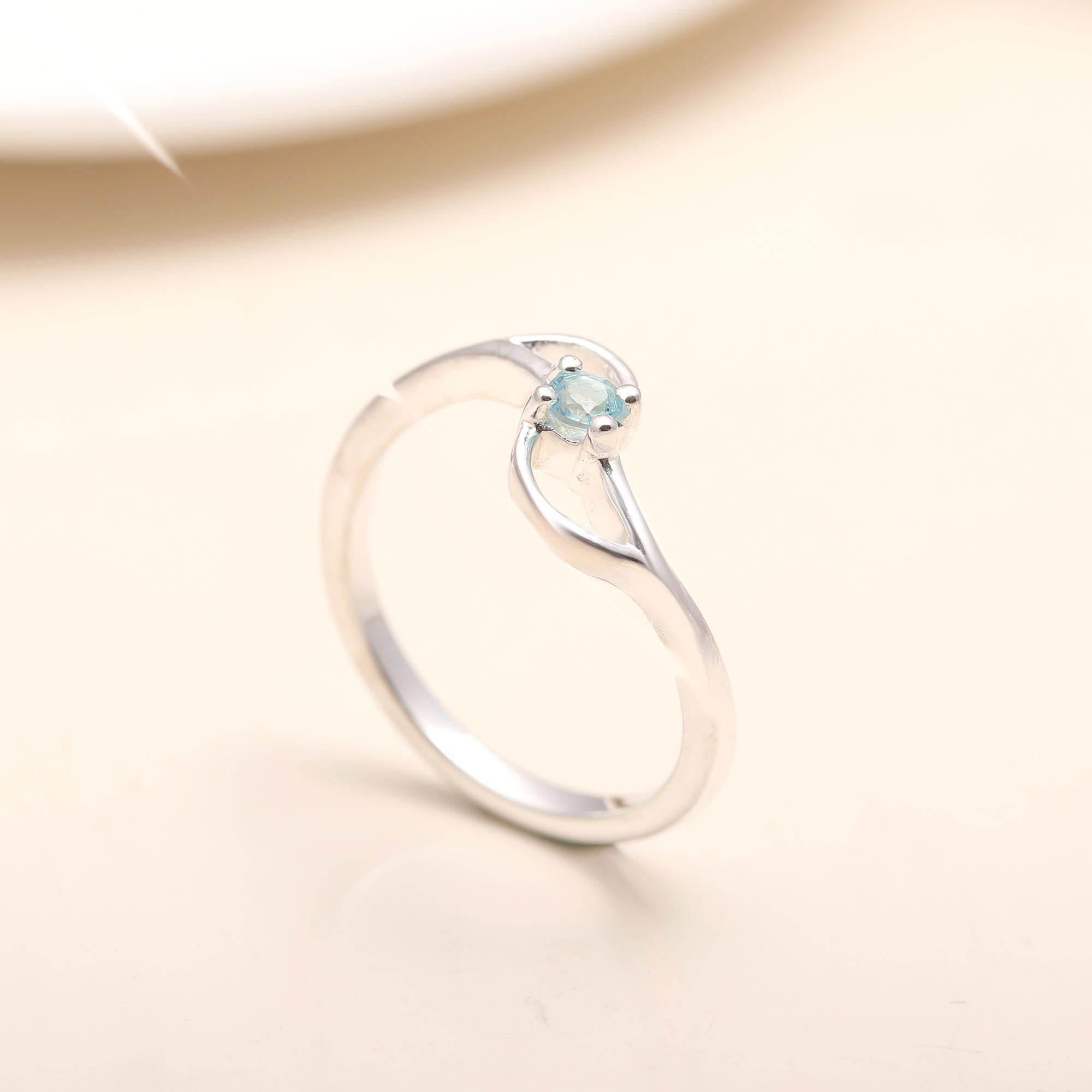 Modern sterling silver twist band ring with blue topaz