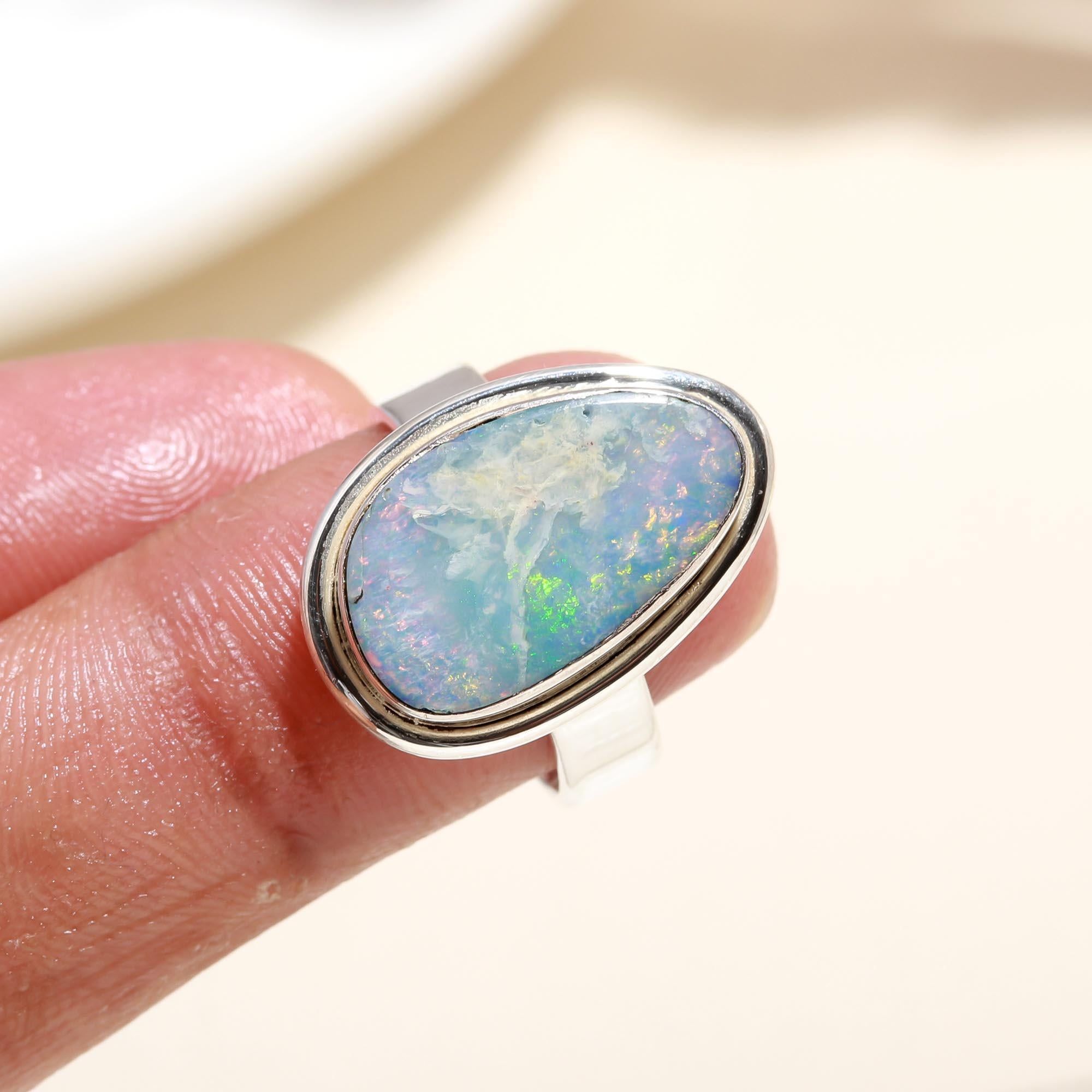 Elegant oval blue opal ring on finger