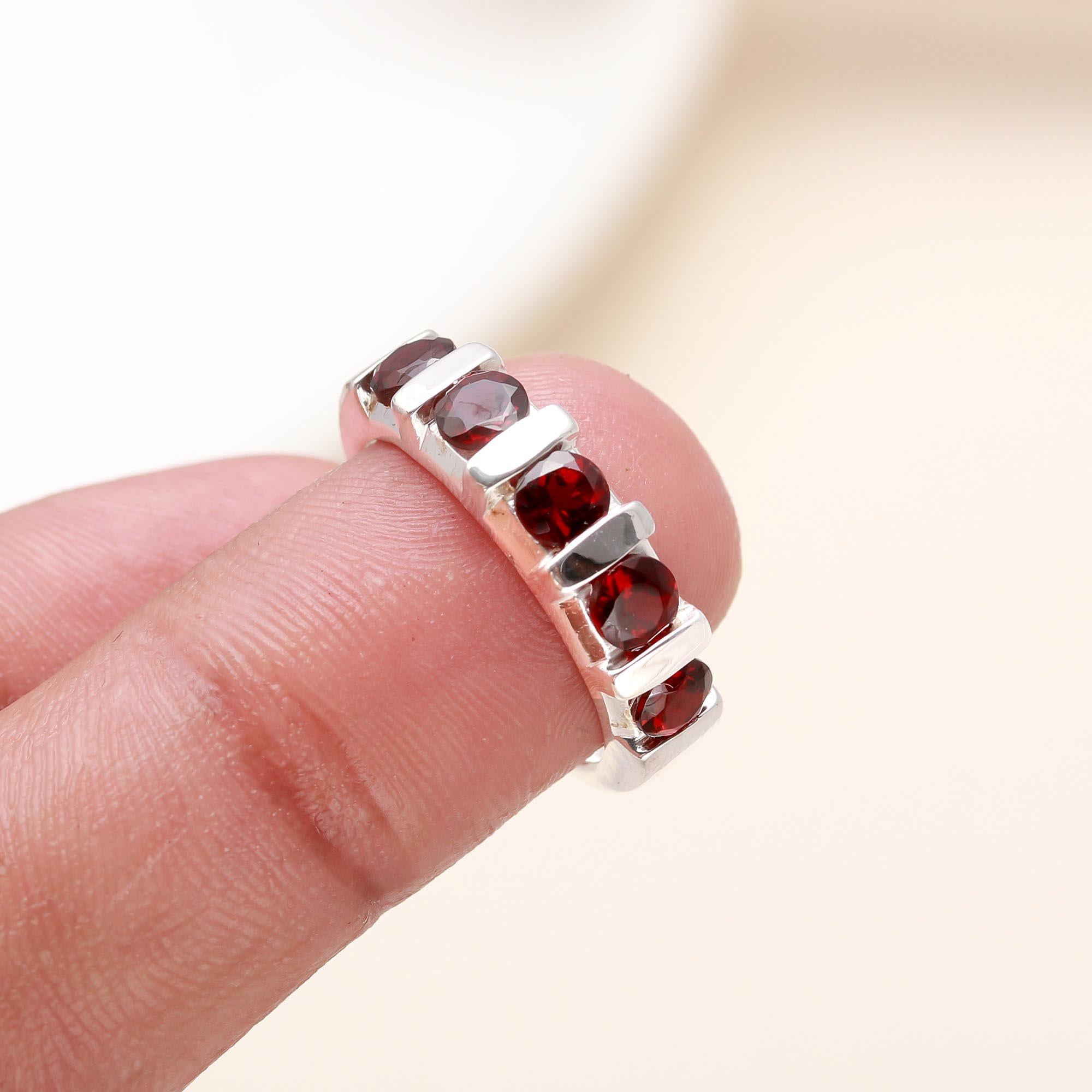 Elegant half eternity garnet ring on finger