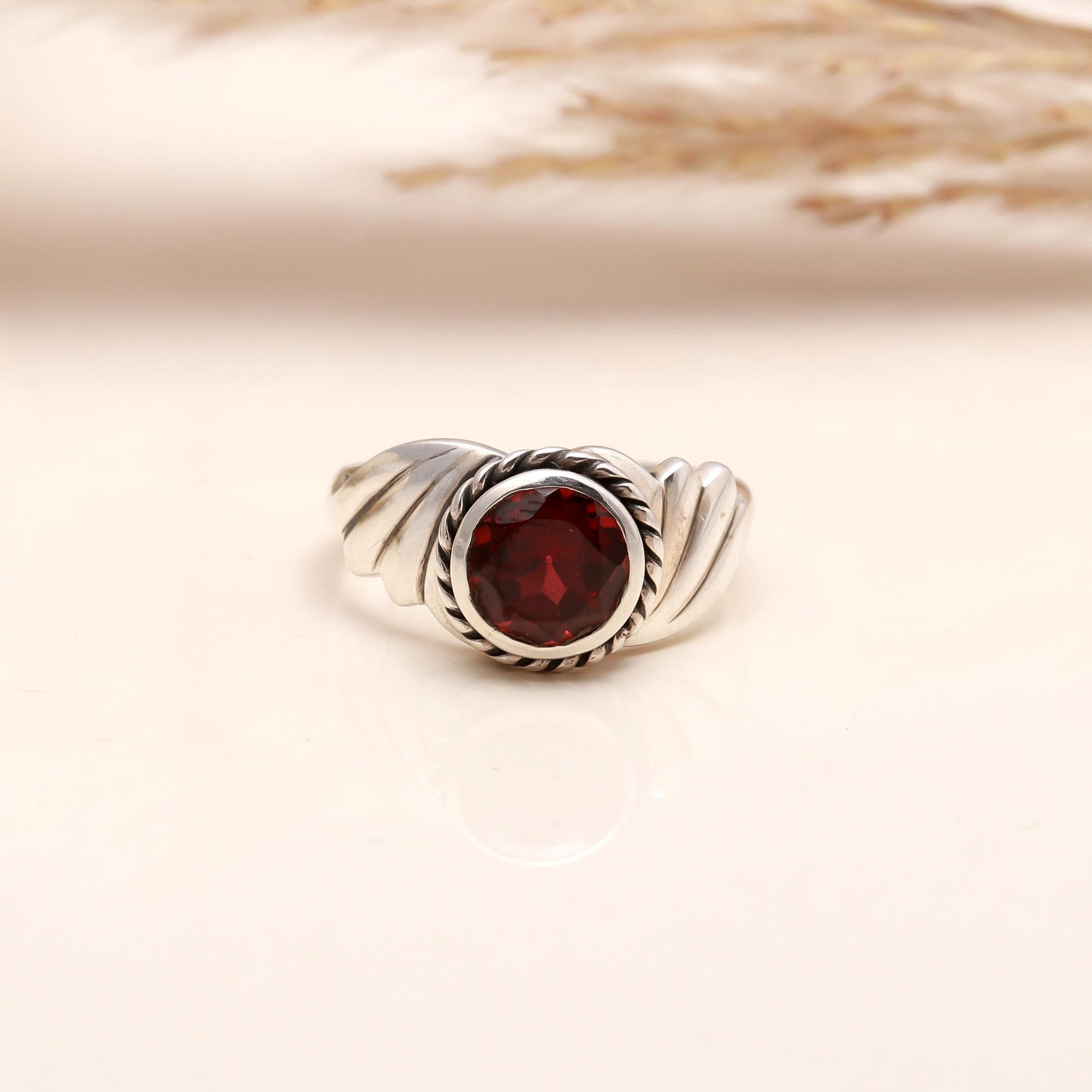 Close-up of round garnet rope design silver ring