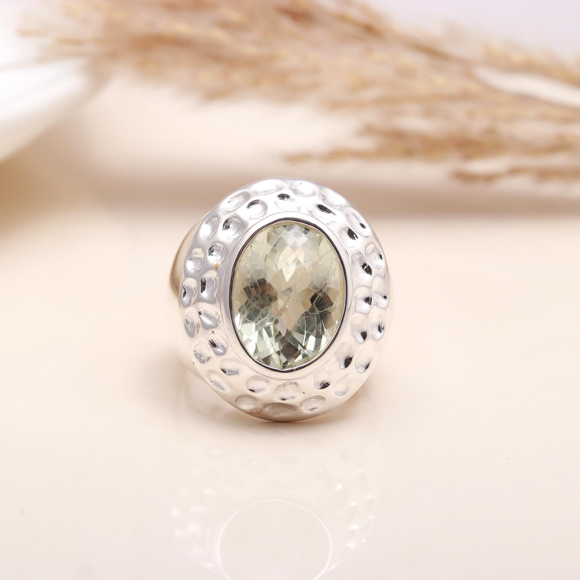 Close-up of oval green amethyst textured silver band ring