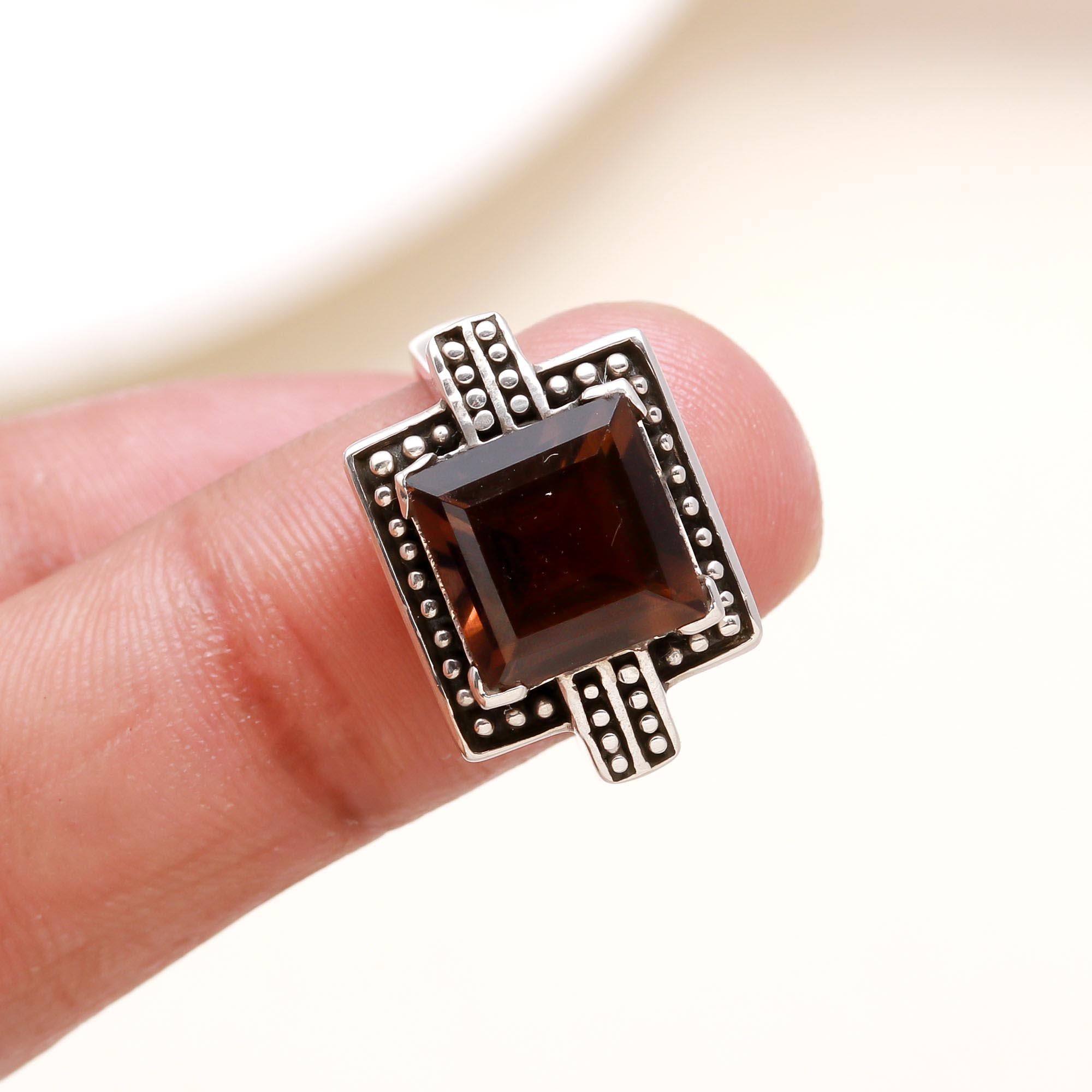 Garnet solitaire silver ring with antique accents on finger