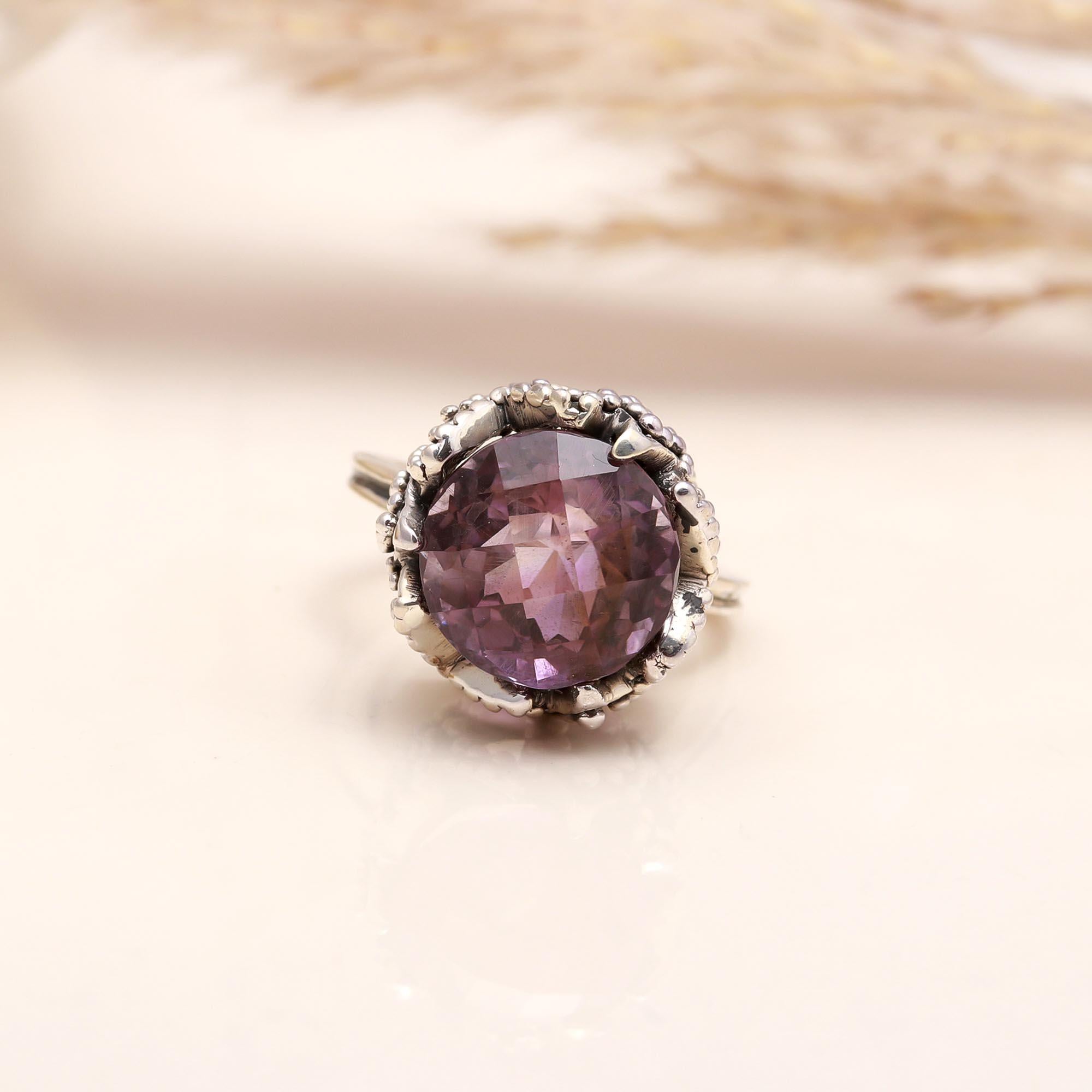 Close-up of faceted oval amethyst in antique silver ring