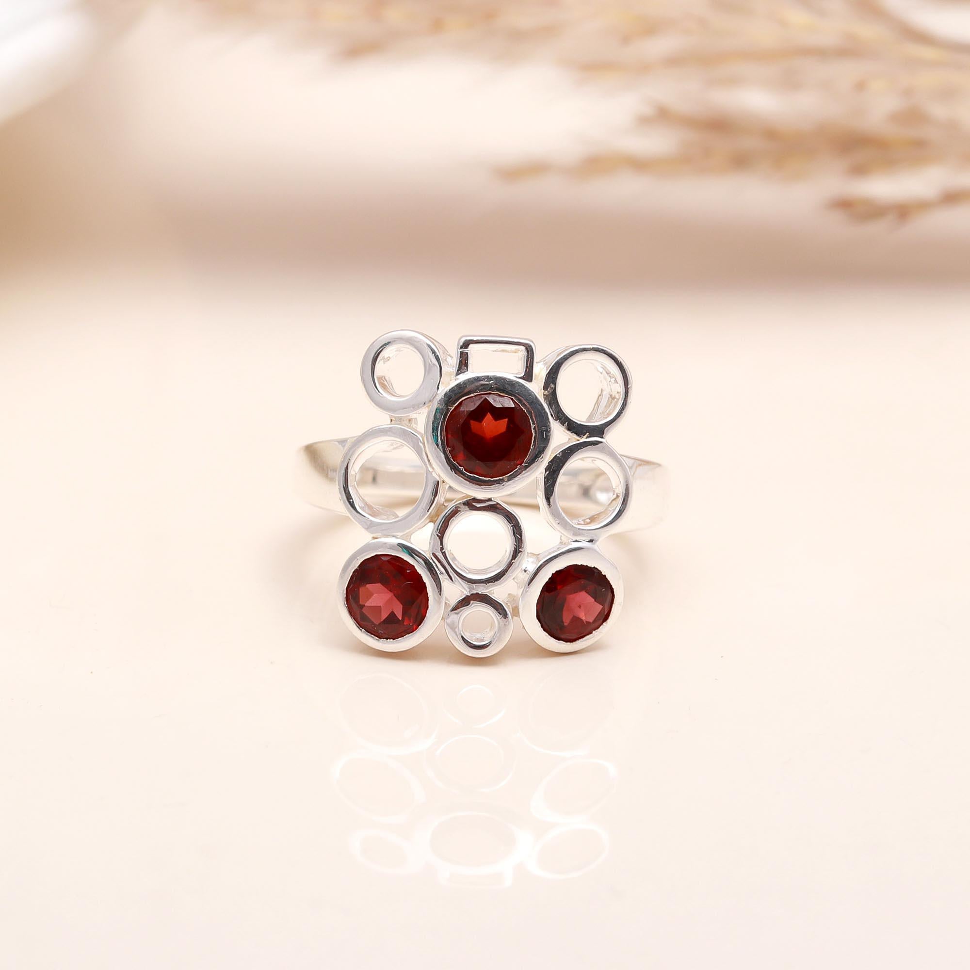 Close-up of garnet circle cluster silver ring
