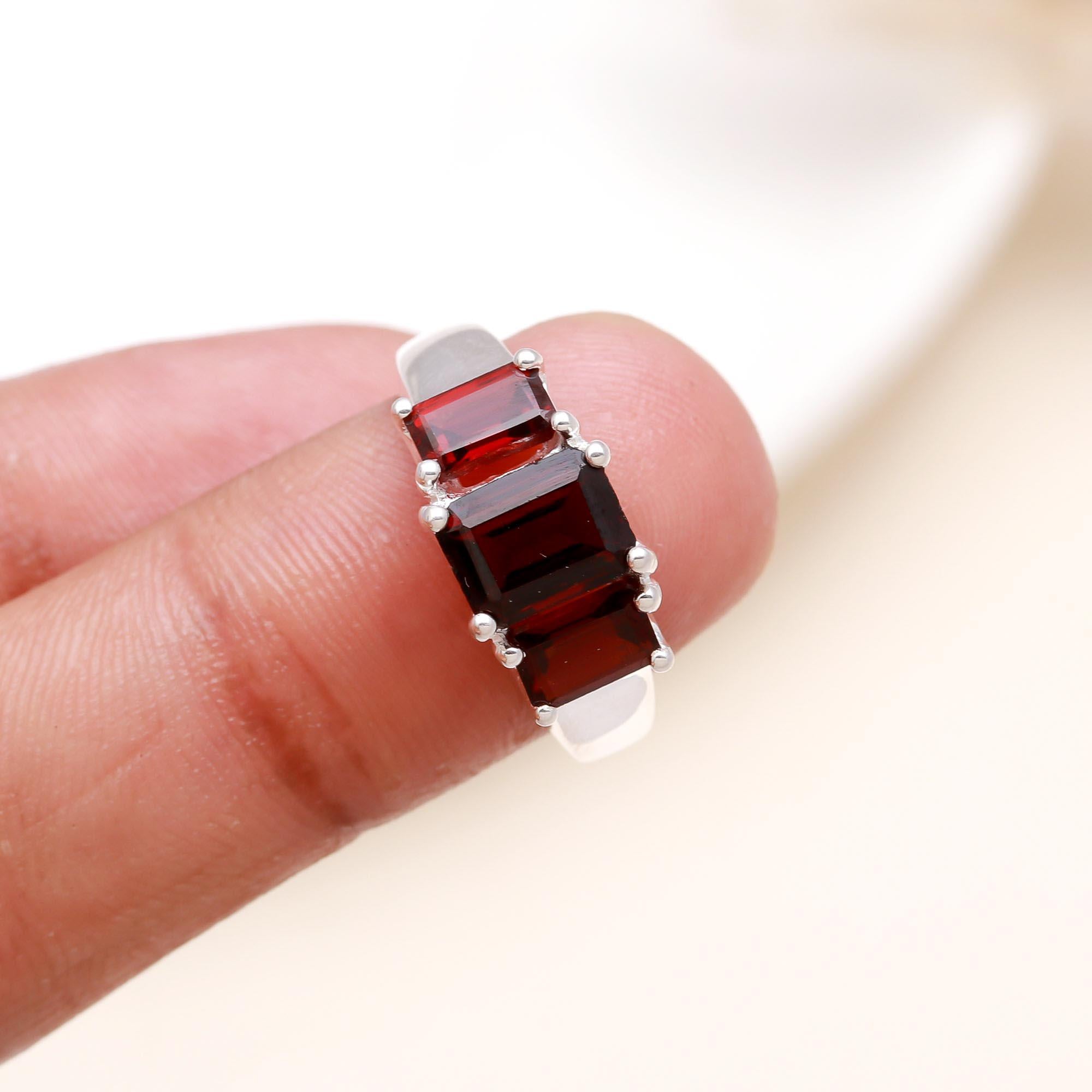 Elegant emerald cut garnet ring on finger