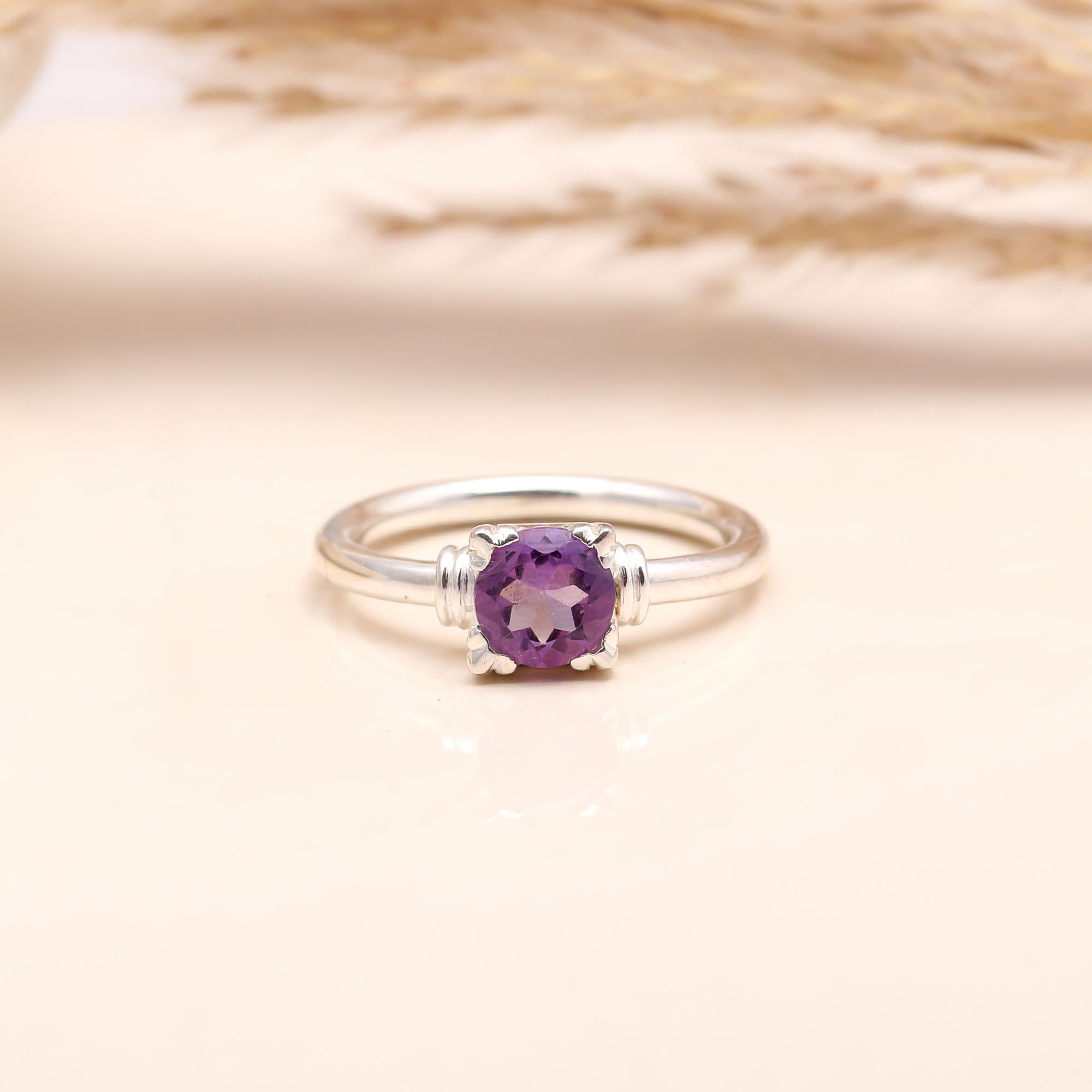 Close-up of round-cut amethyst solitaire silver ring