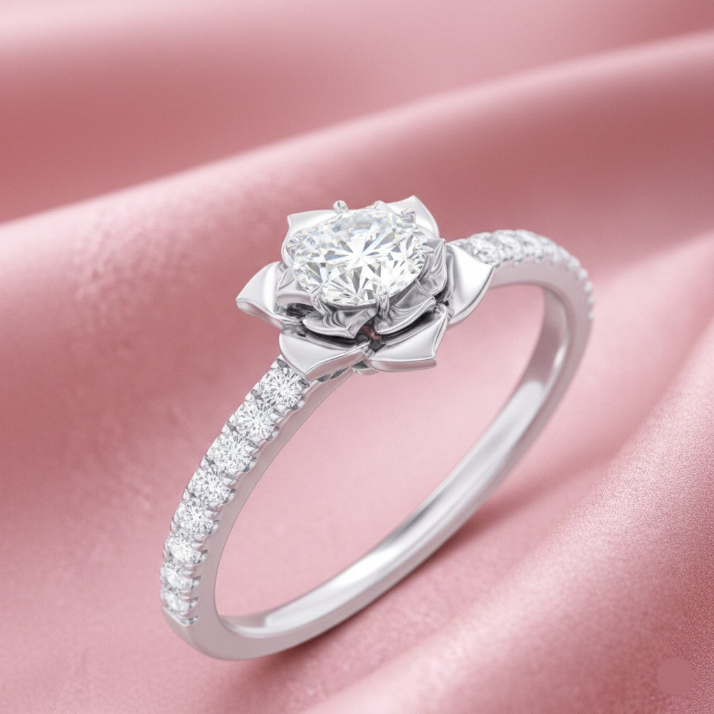 A silver-toned diamond engagement ring with a flower-shaped halo and a pavé-set band, displayed on a soft pink satin fabric background.