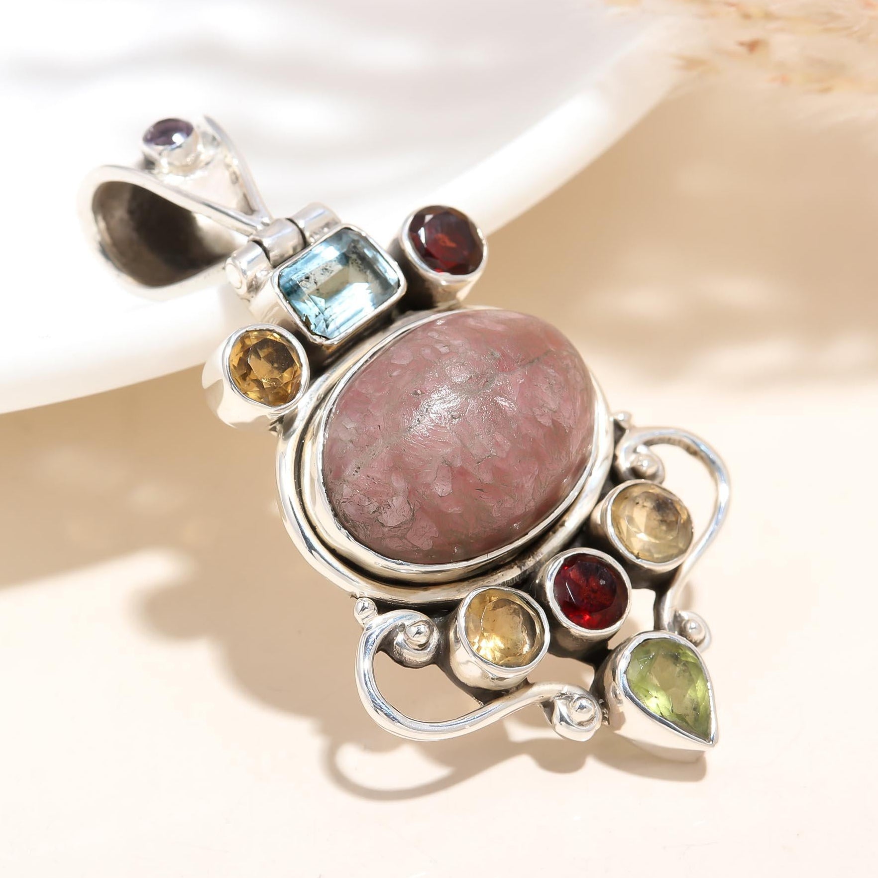 Multicolored gemstone pendant on a light background