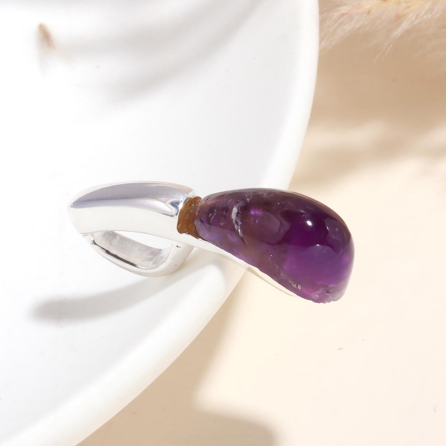 A 925 sterling silver pendant with a raw amethyst gemstone in a minimalist design, displayed against a soft background.