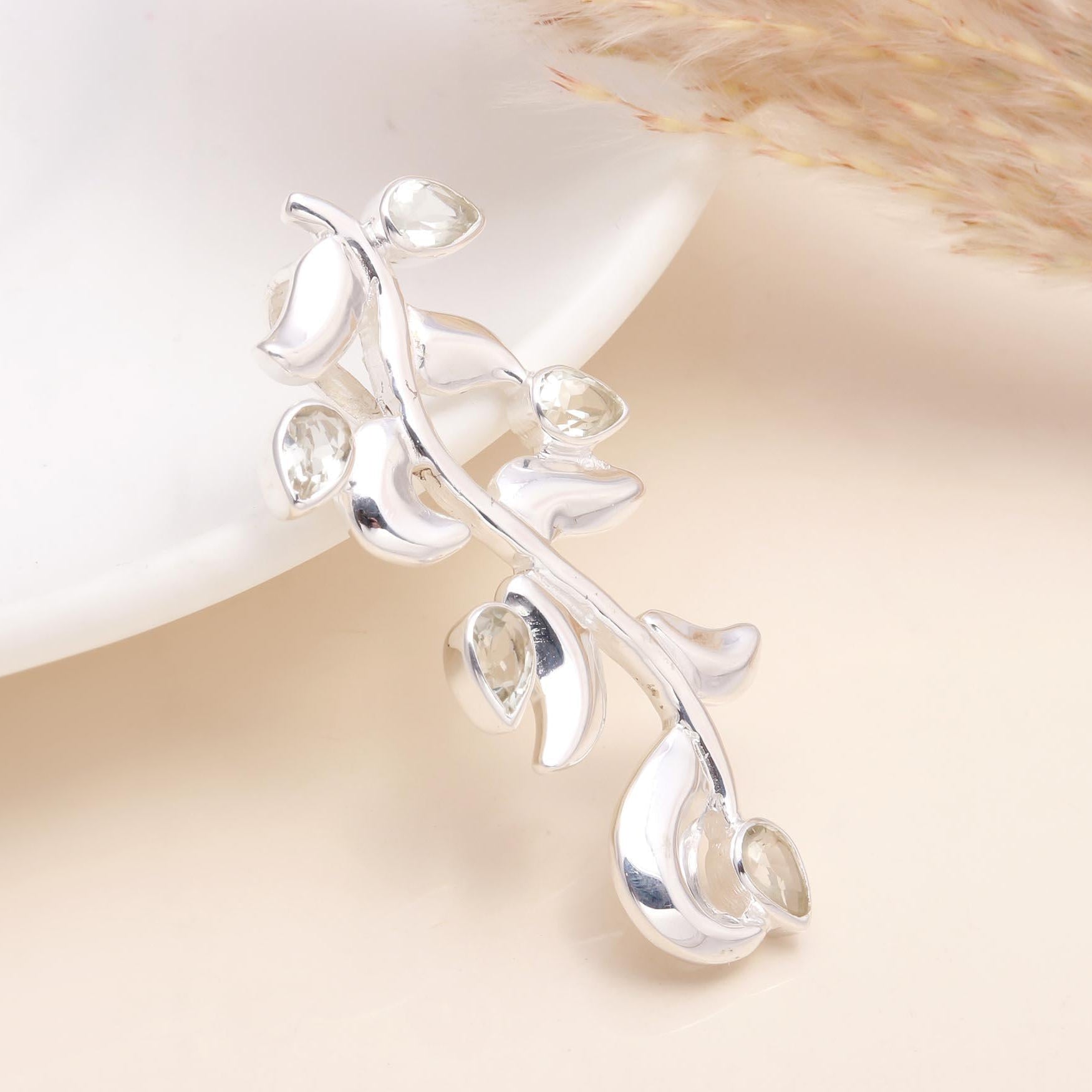 A 925 sterling silver pendant with a clear quartz gemstone carved into a leaf shape, displayed against a light background.
