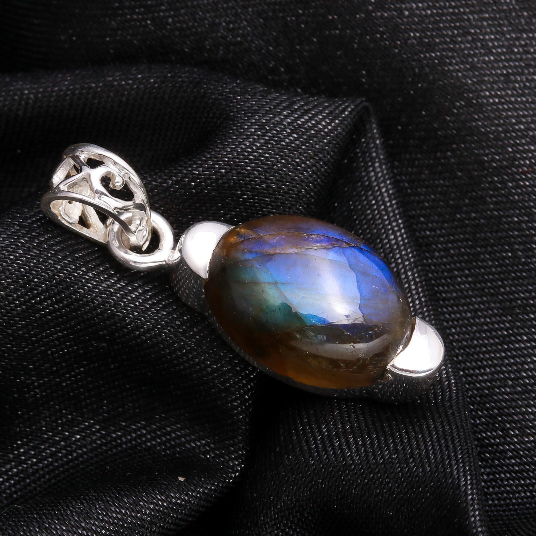 Labradorite pendant with silver setting on a black fabric background