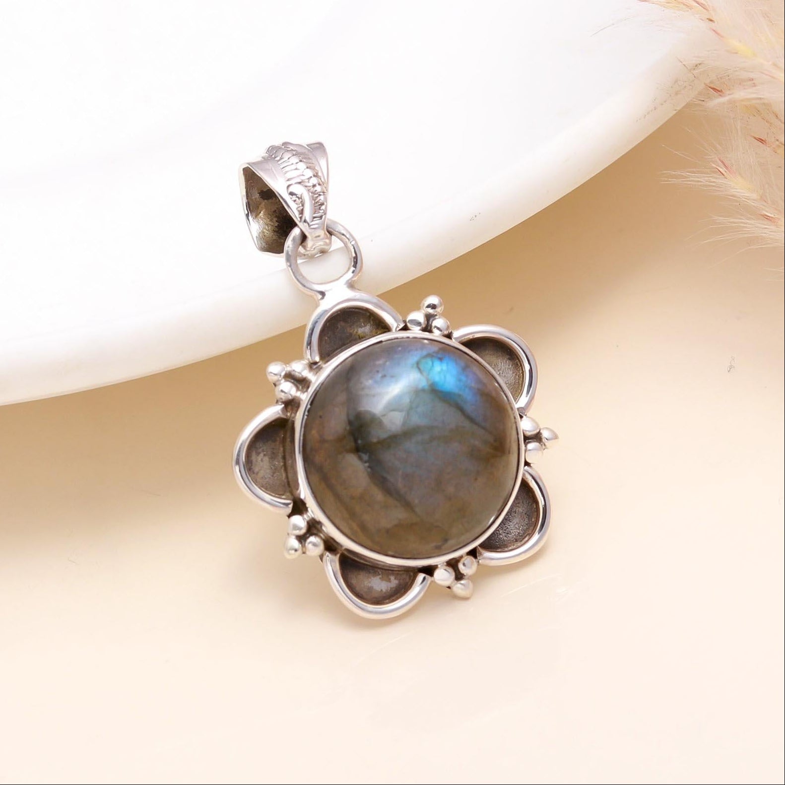 A 925 Sterling Silver pendant featuring a vintage floral charm with a labradorite gemstone in the center, displayed against a neutral background.
