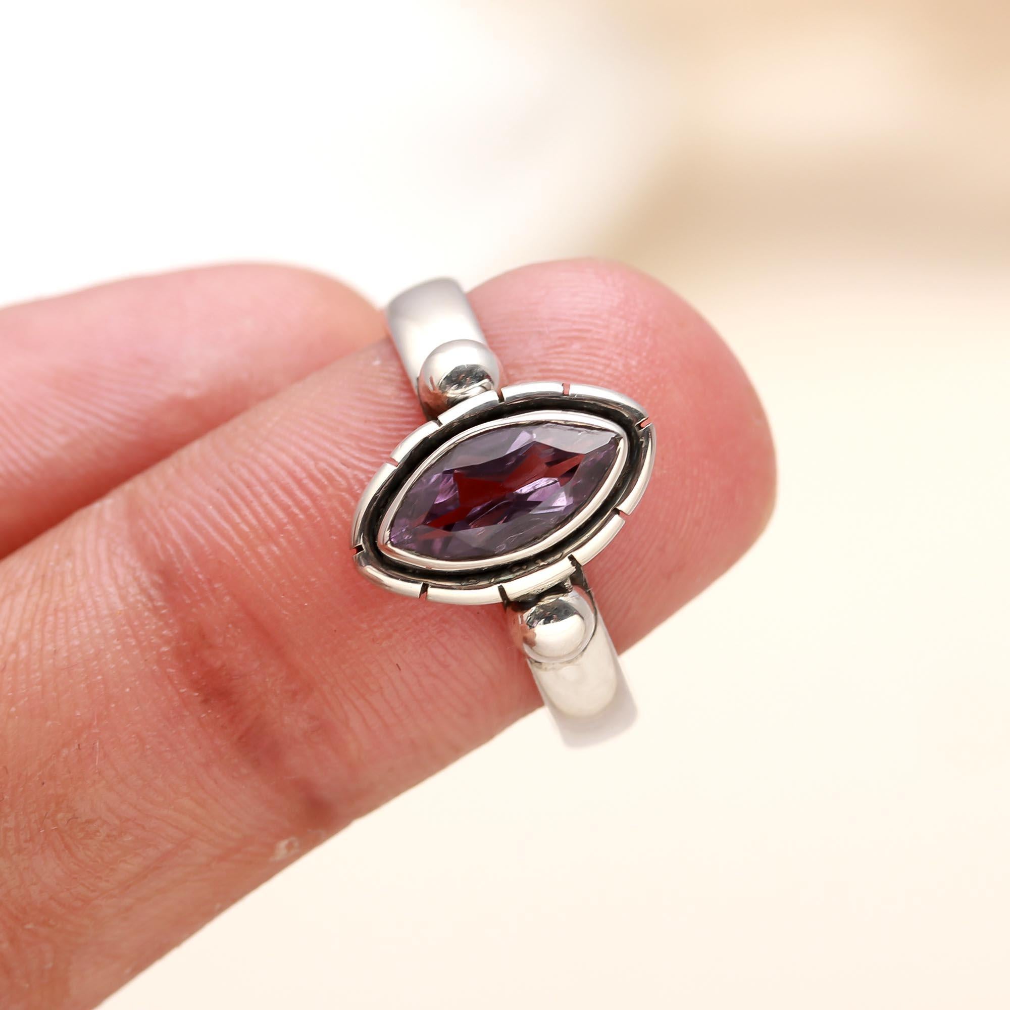 Close-up of marquise-cut amethyst set in sleek silver bezel ring