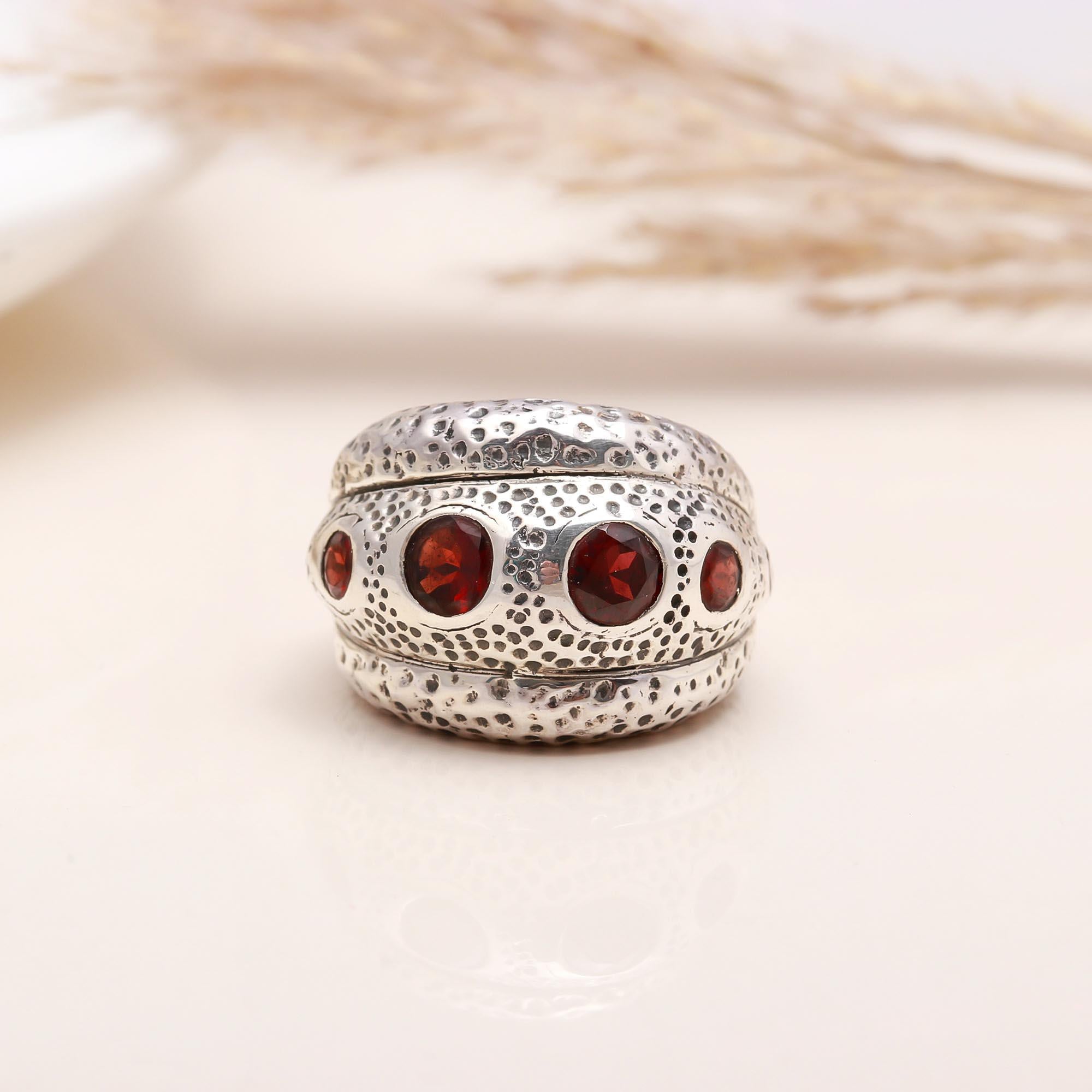 Close-up of red garnet textured silver ring