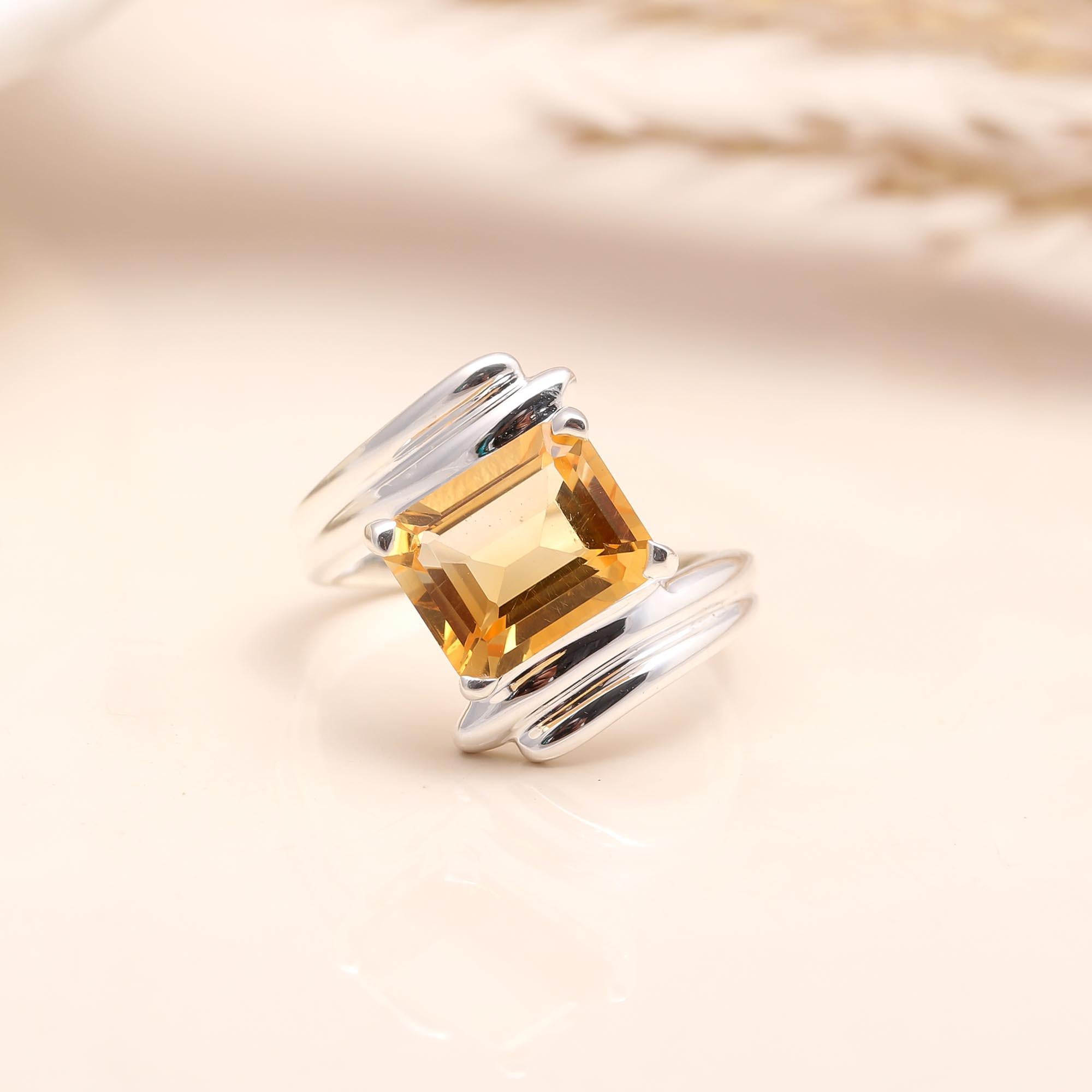Close-up of emerald-cut citrine solitaire silver ring